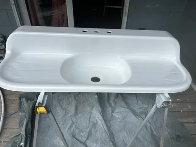 Vintage double drainboard sink after refinishing with a glossy white finish