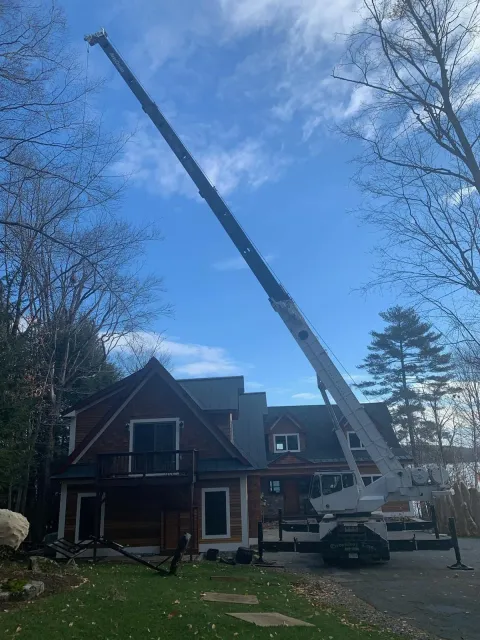 A large crane is sitting in front of a house.