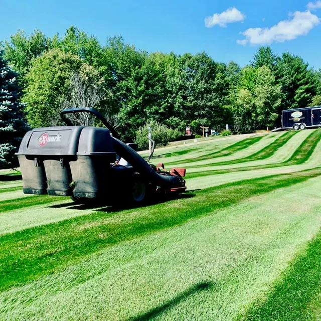 Exmark mower creating neat stripes on a residential lawn, part of Perfect North Lawn Care’s lawn maintenance services in New Hampshire.