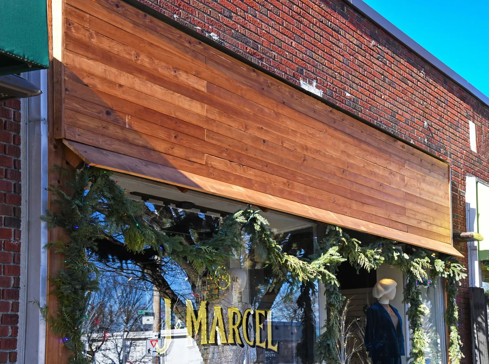 Storefront of J Marcel with custom woodwork sign by LSC Carpentry LLC.