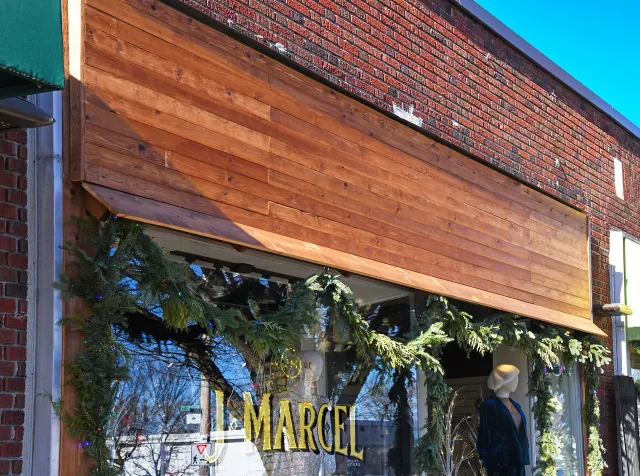 Storefront of J Marcel with custom woodwork sign by LSC Carpentry LLC.