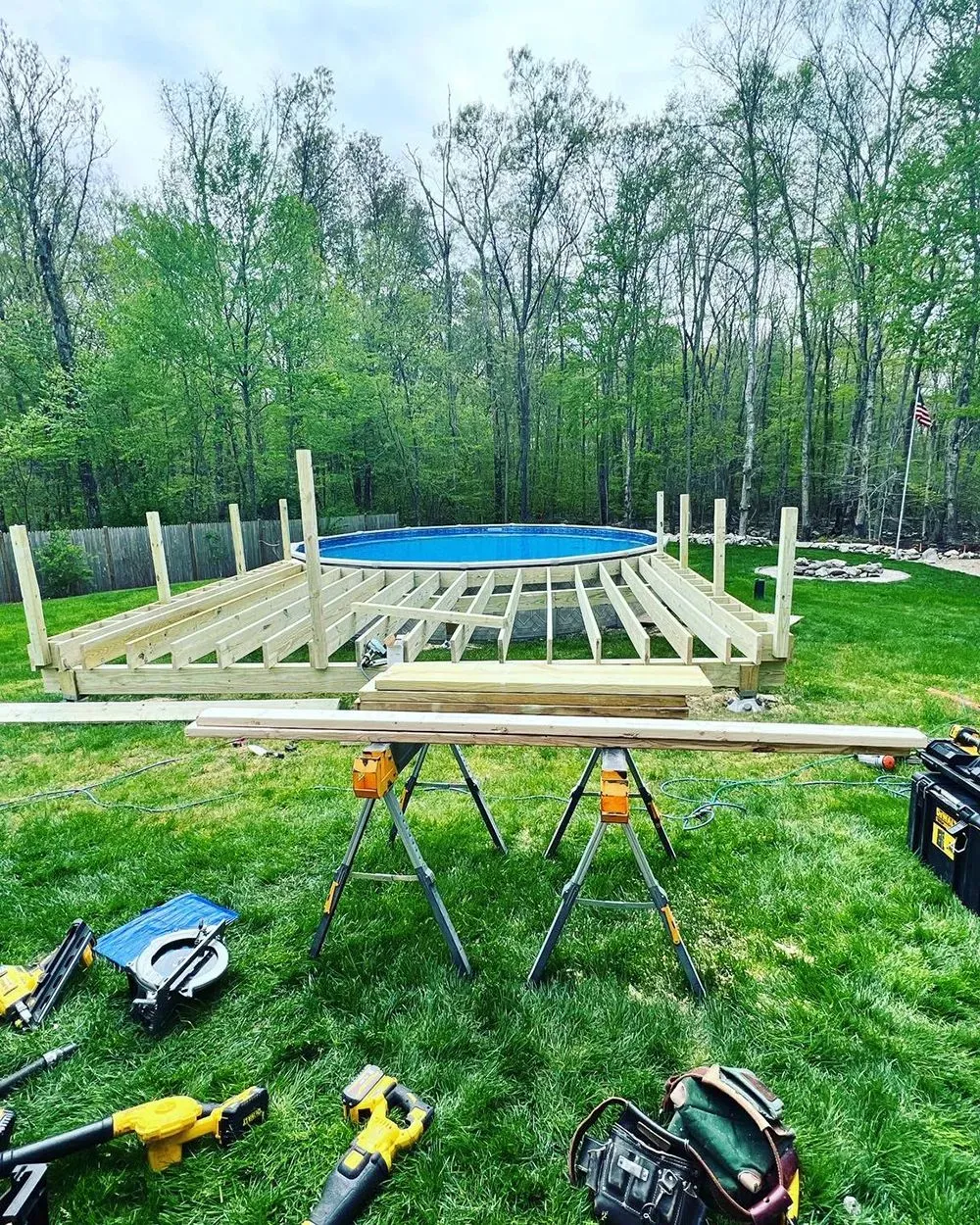 A wooden deck is being built around a swimming pool