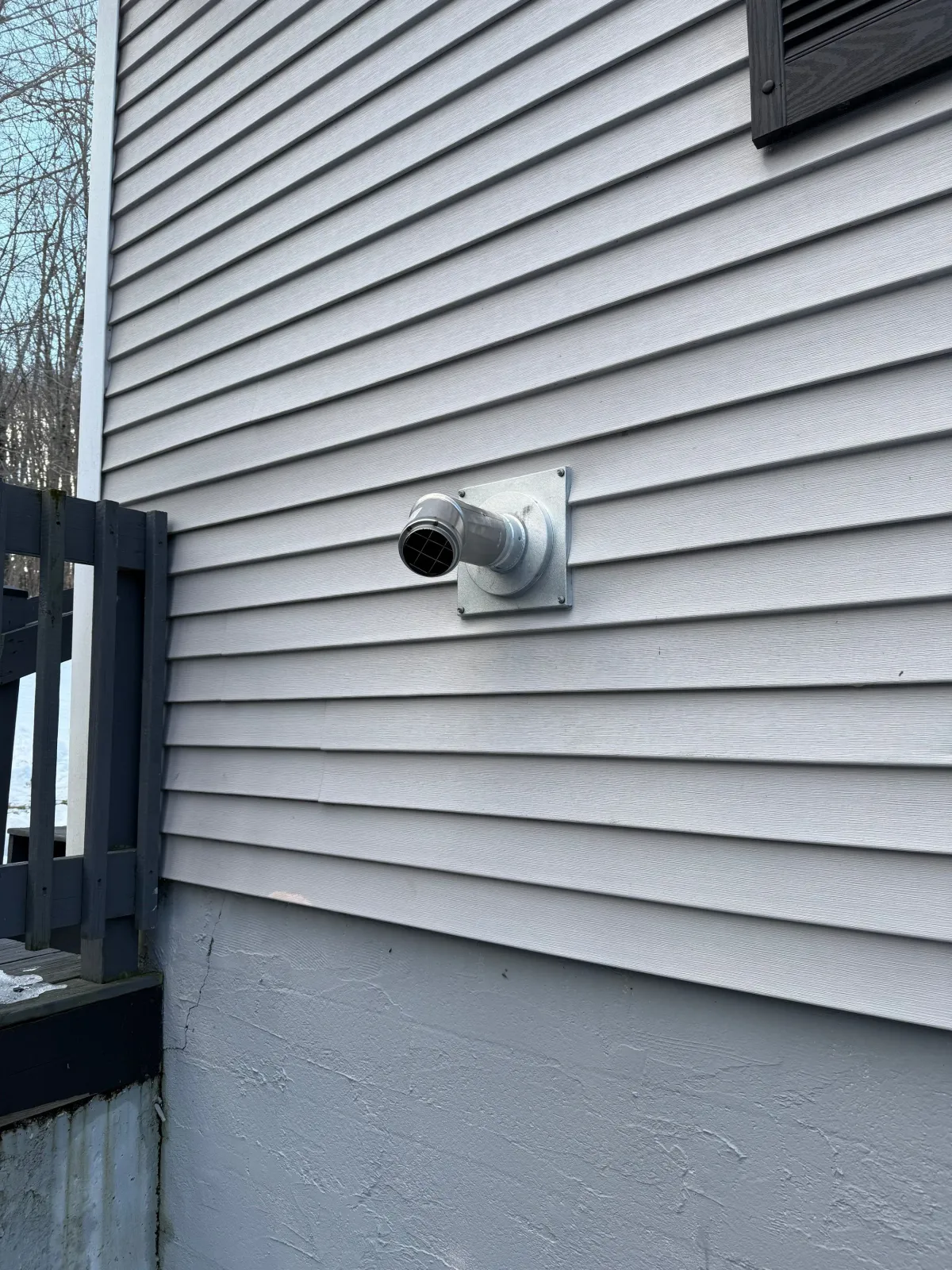 Exhaust vent on the exterior wall of a house.