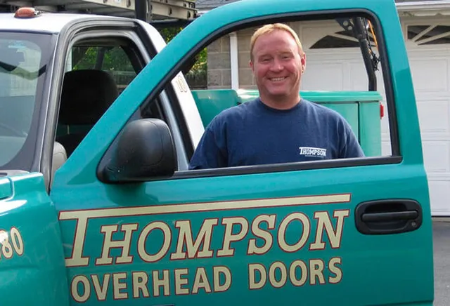 Thompson Overhead Doors expert in Natick standing next to the service truck