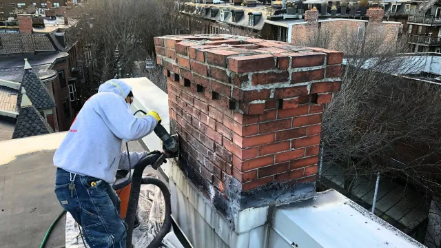 Chimney masonry repair project in progress on a historic Boston, MA property