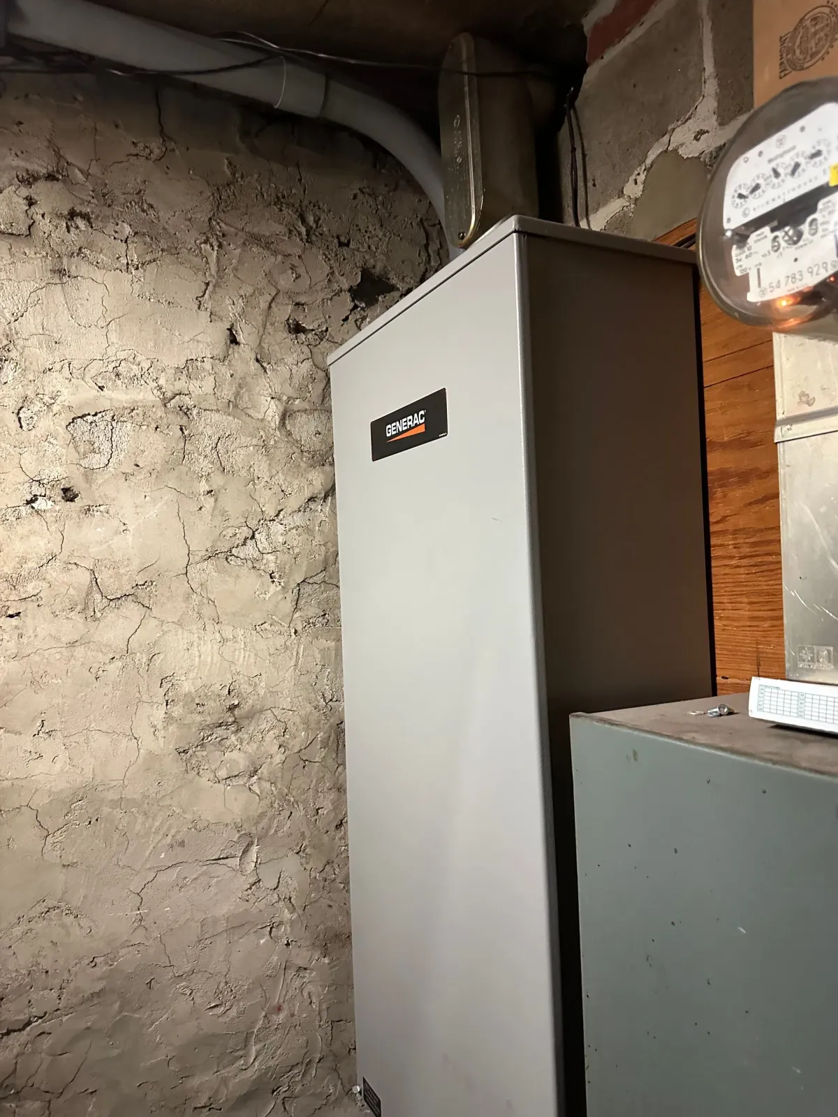 A white box is sitting next to a brick wall in a room.