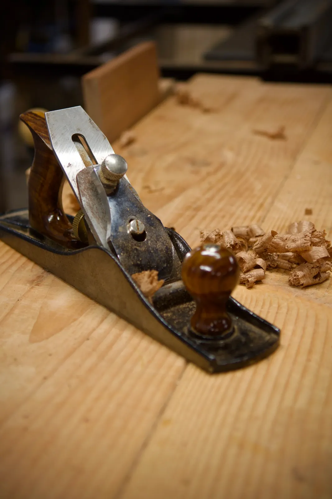 Woodworking hand plane on wooden surface with wood shavings