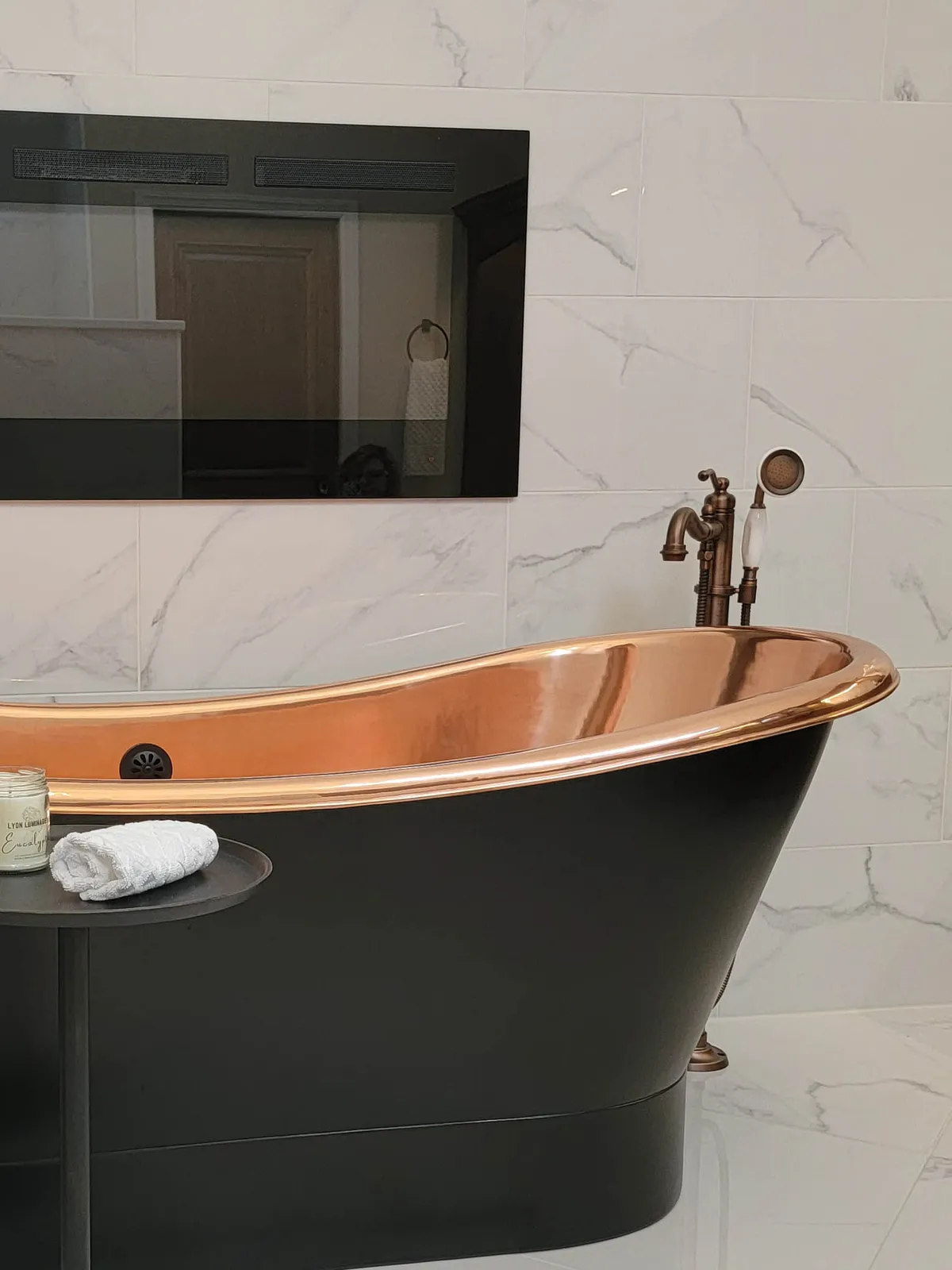 Haute Designs Kitchen & Bath. Interior Design. Freestanding copper bathtub. Oil-rubbed hardware & fixtures. Electric fireplace Porcelain tiles with marble look.