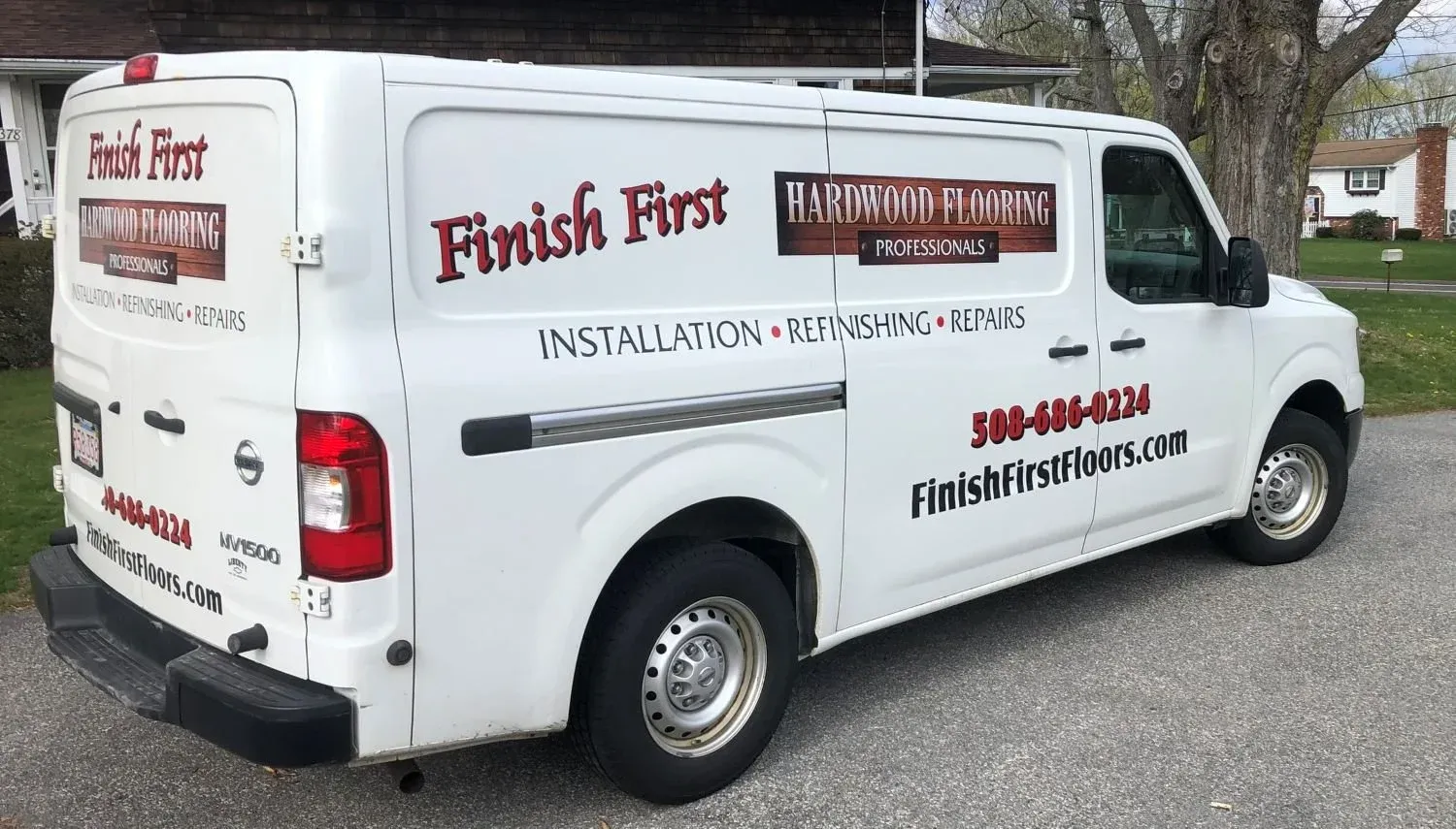 Finish First Hardwood Flooring lettered work van with information advertising installation, refinishing, and repairs