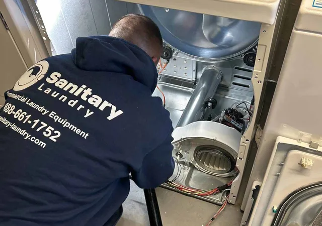 Man cleaning dryer with specialized laundry maintenance equipment