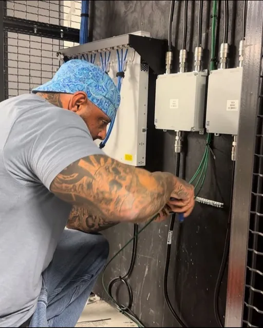 Electrician Working on Wiring and Electrical Equipment in a Server Room