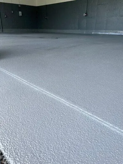 A close up of a gray concrete floor in a golf facility.