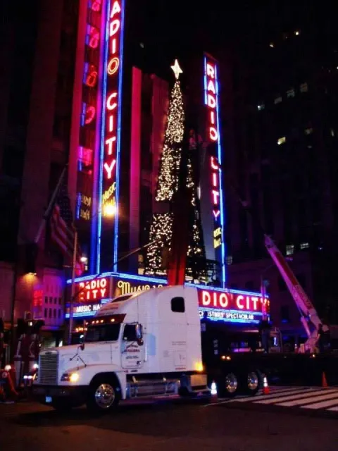 A truck is parked in front of a radio city building