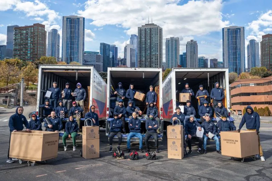 stark movers inside their moving trucks, while having boston skyline in the background