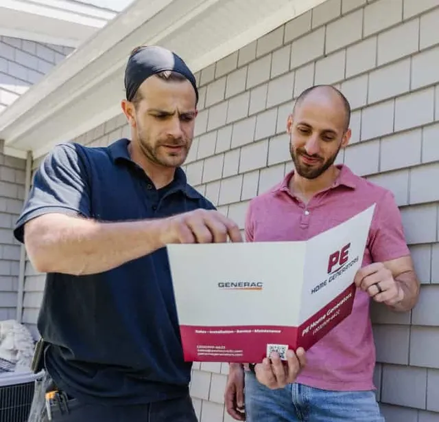 Two men reviewing a PE Home Generators brochure featuring Generac products.
