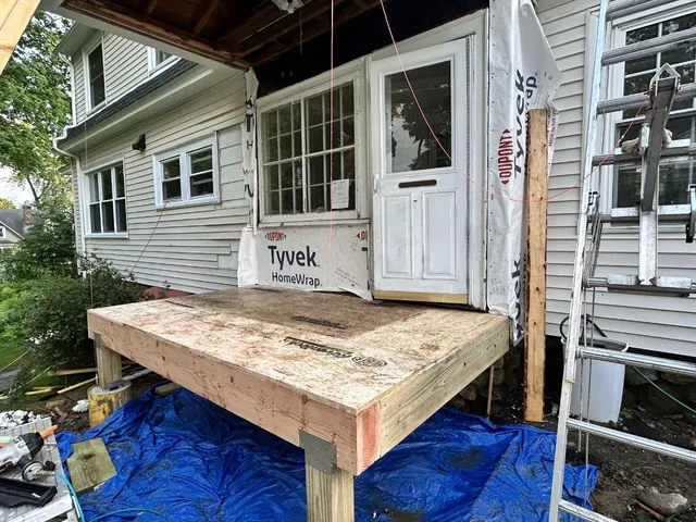 Before: the same addition mid-build, subfloor framed and the wall wrapped in house wrap
