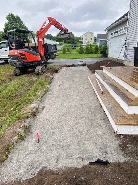 Excavation and site preparation for new landscape installations, including grading and hardscaping in Vermont.