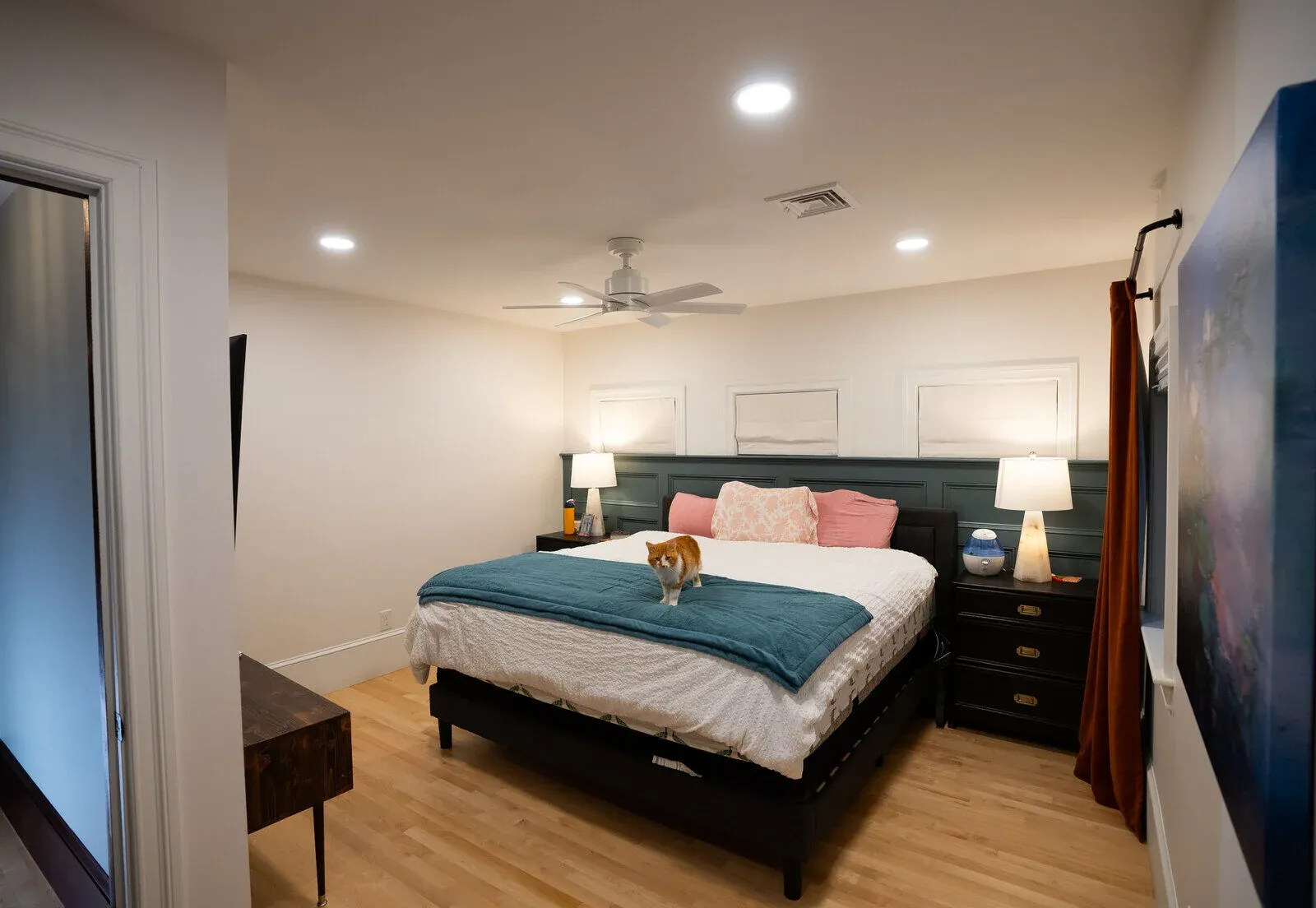 Spacious bedroom with wooden flooring and a cozy bed, a project by Oxland Builders in New Hampshire