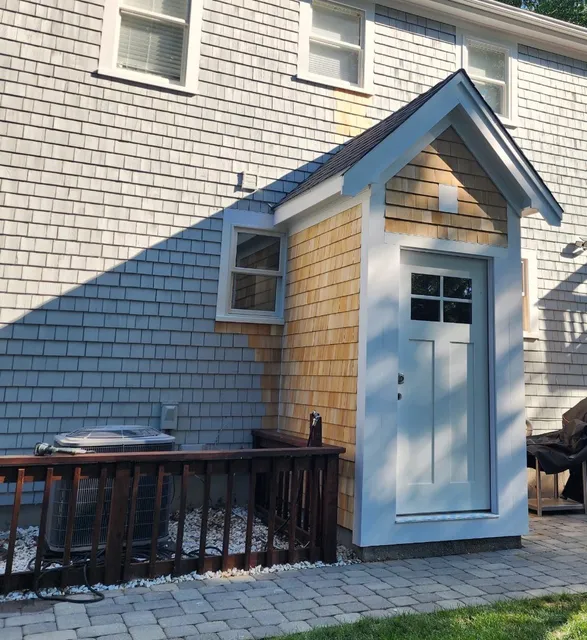Finished back entry addition with cedar shingle siding, new trim and door