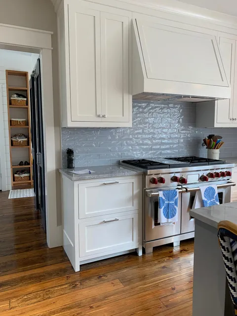 Custom white kitchen with hood surround and pantry cabinetry
