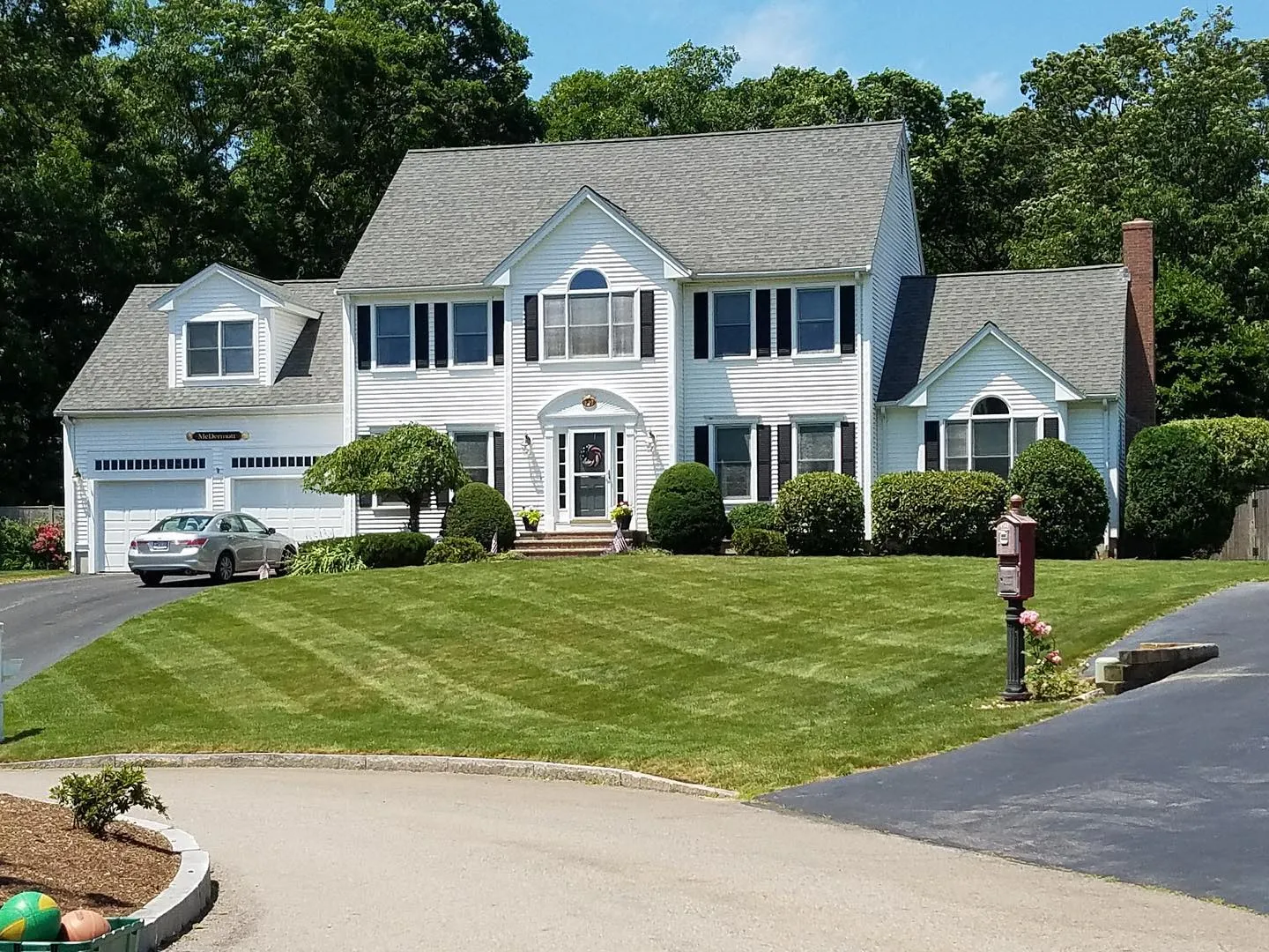 Colonial with mown lawn and edged driveway beds
