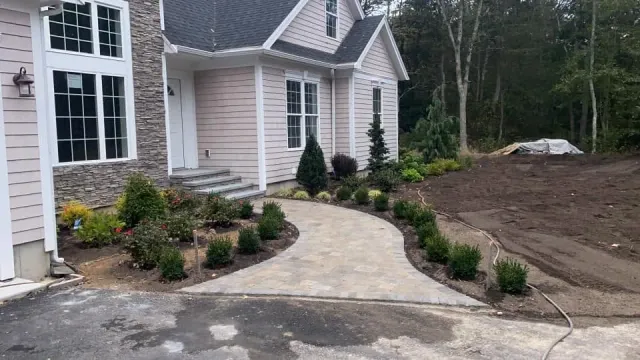 Curving light paver walkway approaching a home entrance