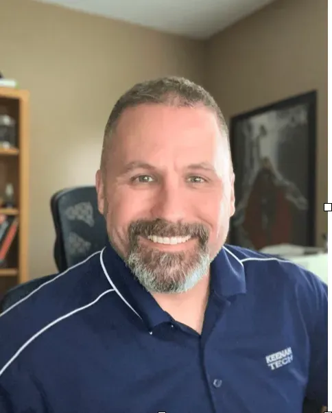 A man with a beard is wearing a blue shirt.