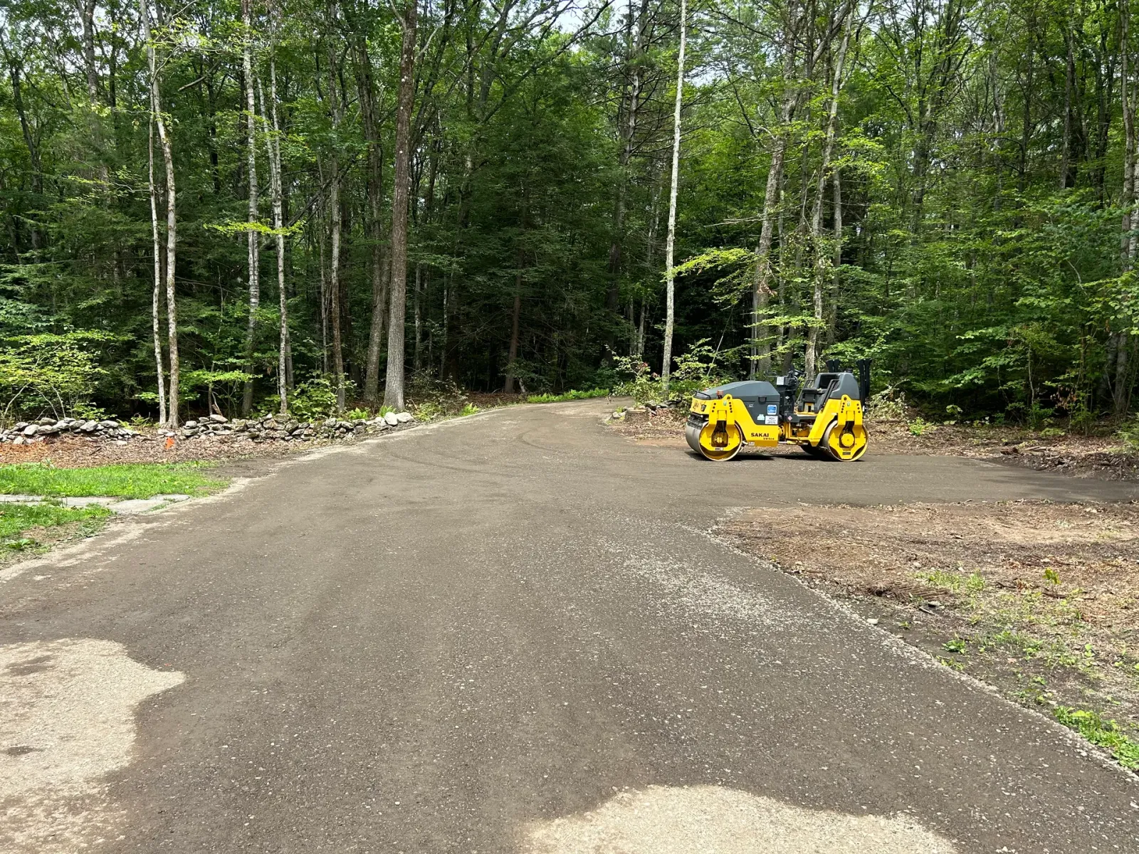 New gravel driveway graded and compacted in a wooded setting, Pelham MA