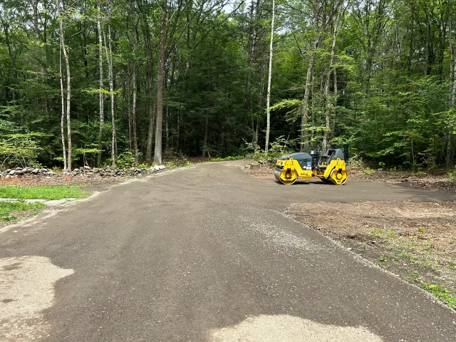 New gravel driveway graded and compacted in a wooded setting, Pelham MA