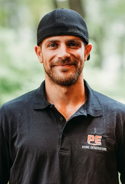 Man wearing a black PE Home Generators polo and cap.
