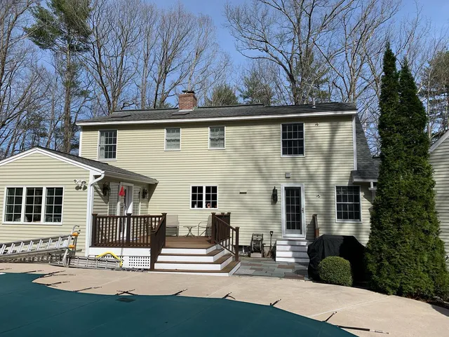 Custom composite deck with black railing behind a home