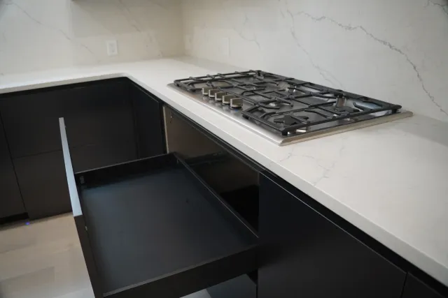 Deep dark drawers opened beneath the cooktop