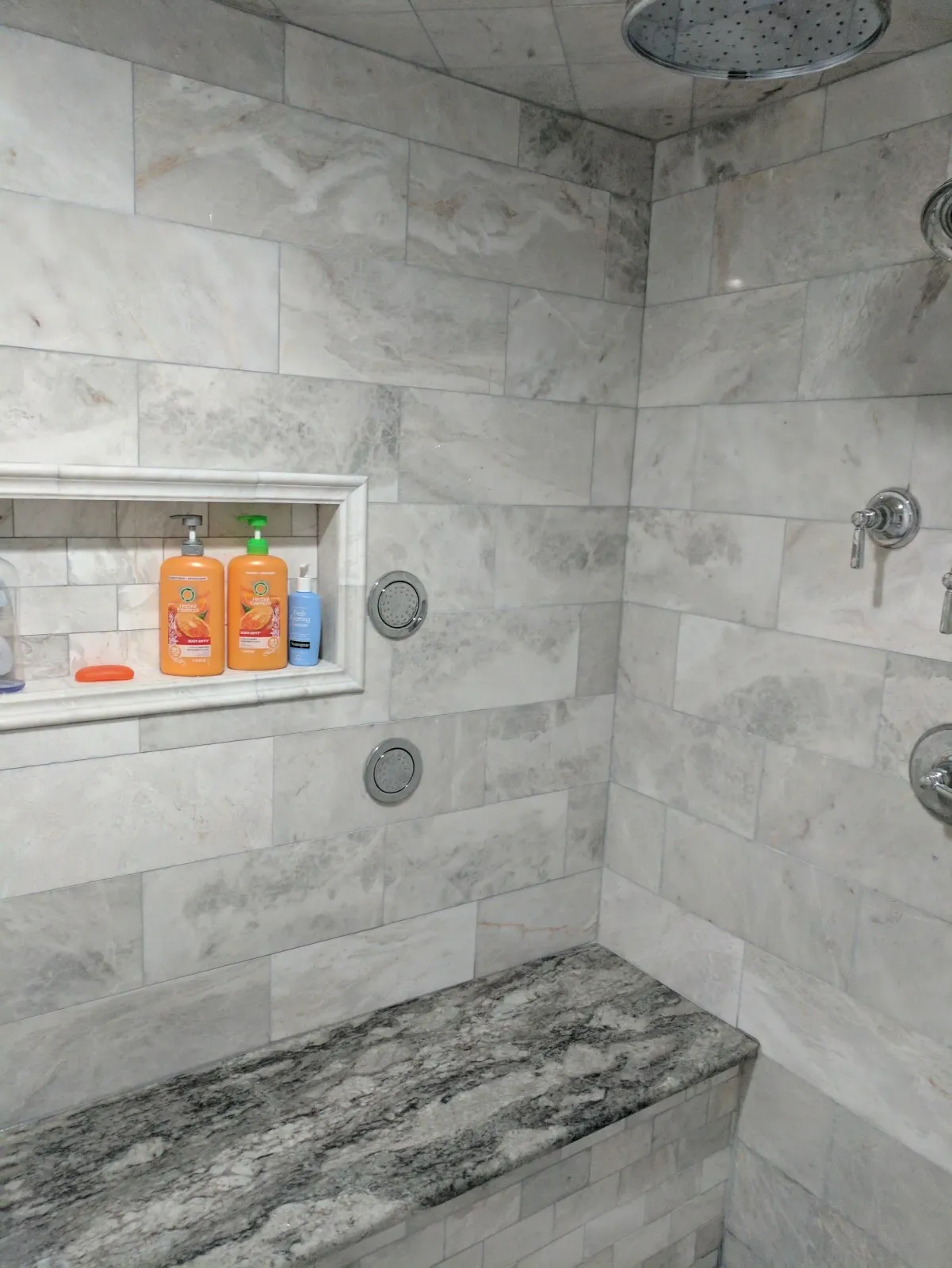 A bathroom with a shower and a bench.