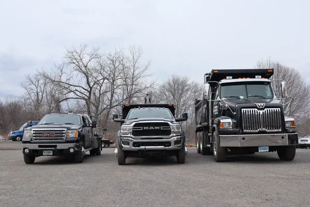 John H. Bensavage LLC fleet of trucks lined up — GMC, RAM, and Western Star dump truck