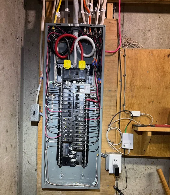 New breaker panel installed on a plywood backboard after the service upgrade in Deering, NH