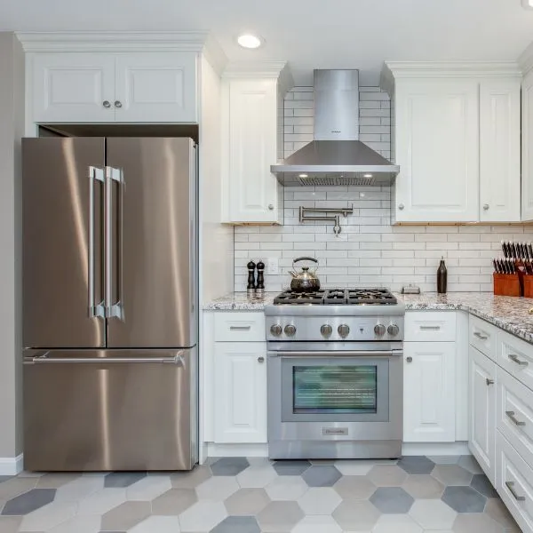 Custom kitchen renovation with hexagon tile floors, subway tile backsplash, and stainless steel appliances in North Hampton, NH