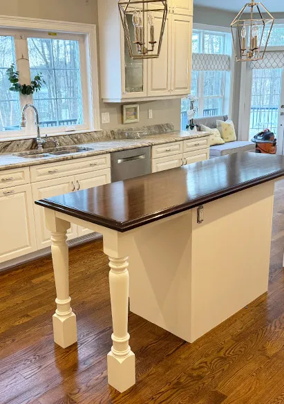 A beautiful kitchen island had a fresh coat of dark stain on the counter, with a country cream base paint.  Walls were painted silver.