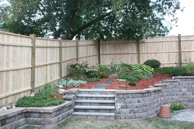 Cedar stockade privacy fence above a stone retaining wall