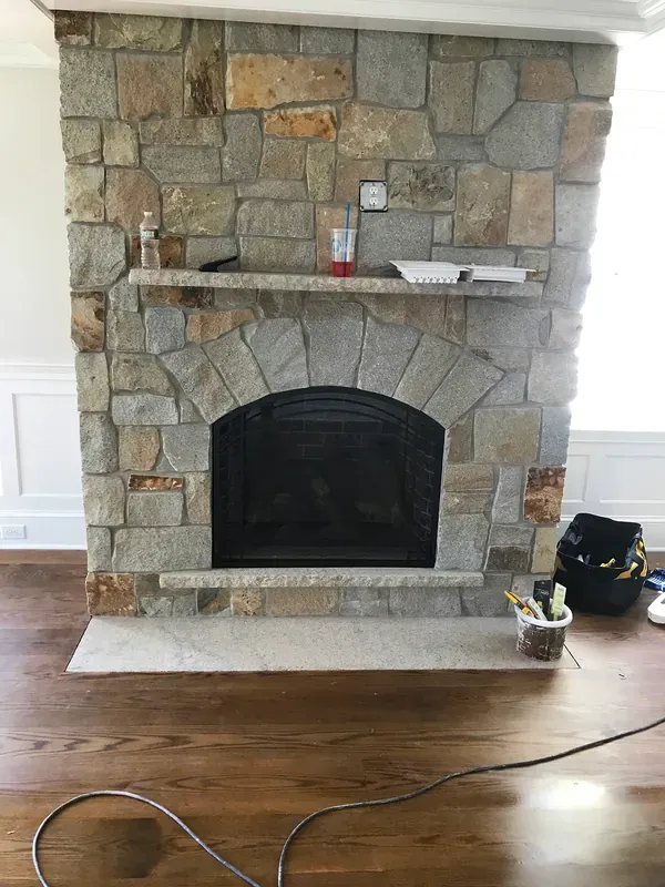 A stone fireplace surround during installation