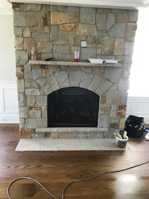 A stone fireplace surround during installation