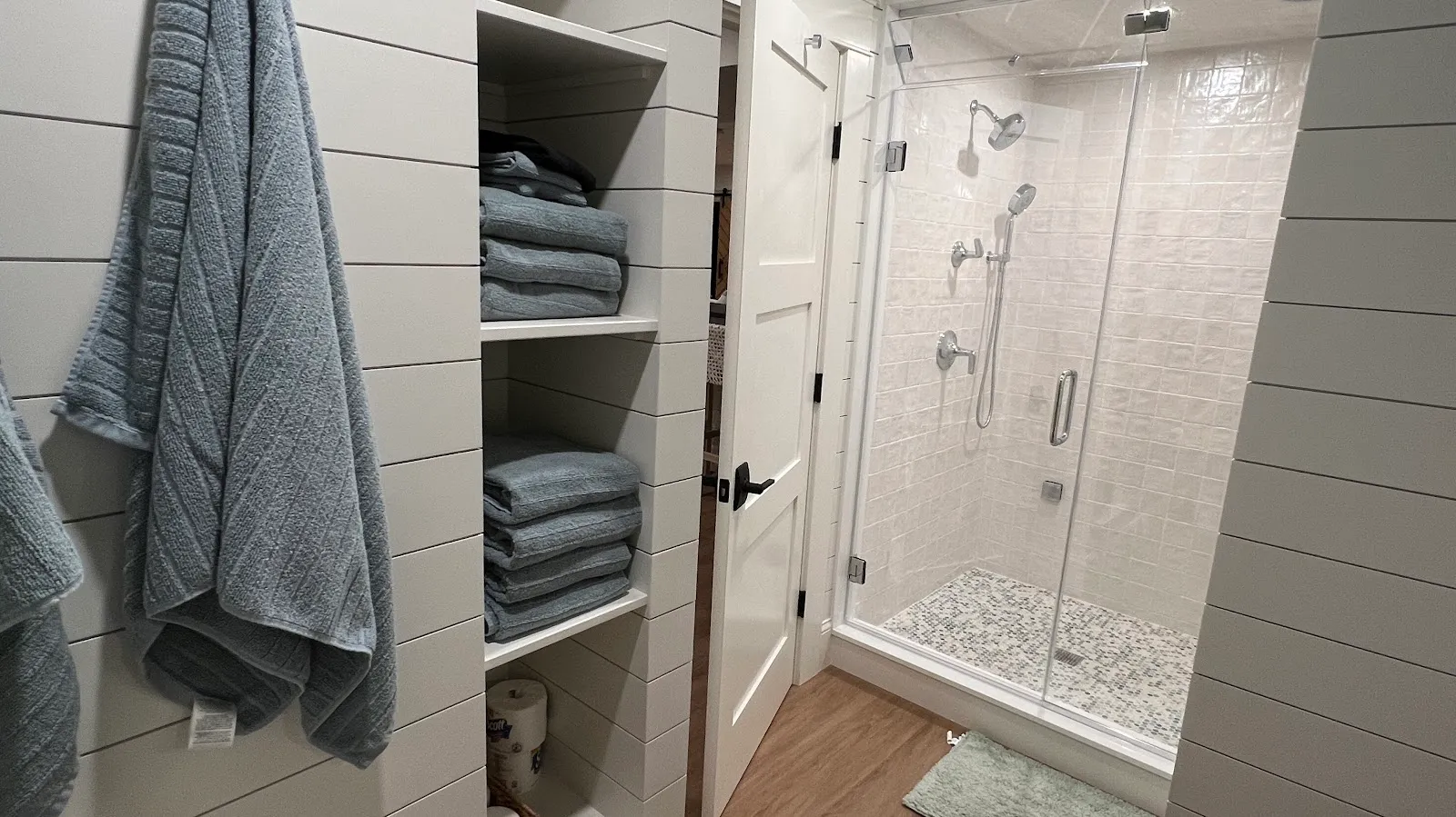 Tiled walk-in shower and built-in linen shelving