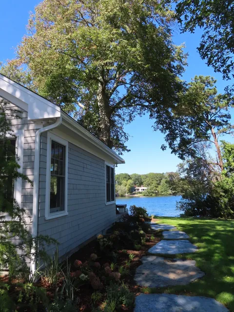 An addition on a house with a walkway to the water views on Cape Cod