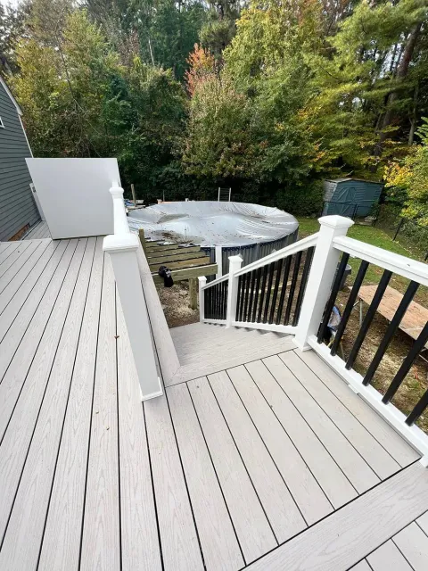 A deck with stairs leading up to a pool