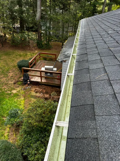 Clean, debris-free gutter after professional cleaning near a backyard deck