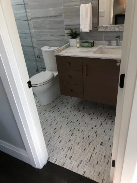a bathroom with a toilet, sink and mirror