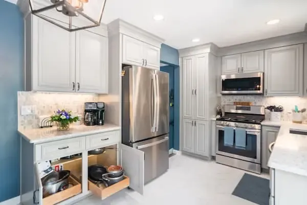 white kitchen cabinets with pull out drawers and aqua blue walls