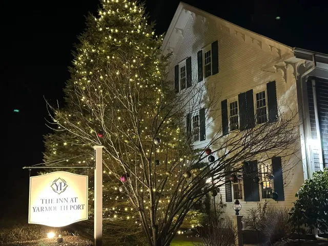 White building with Christmas lights; sign reads