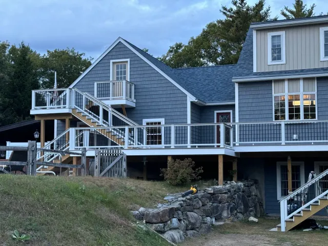 A large house with a large deck and stairs.