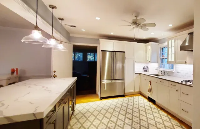 A kitchen with stainless steel appliances and white cabinets