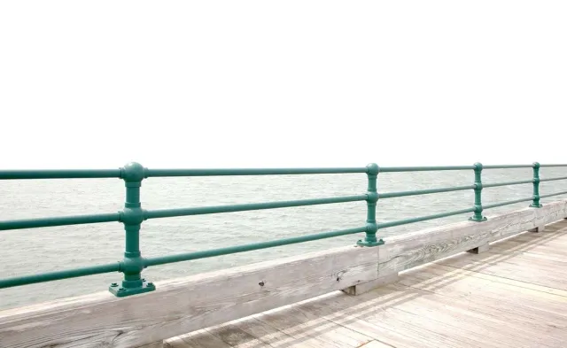 A waterfront railing comprised of ball-shaped iron castings that hold together pipe railing.  Replica railing, cast pipe connection.